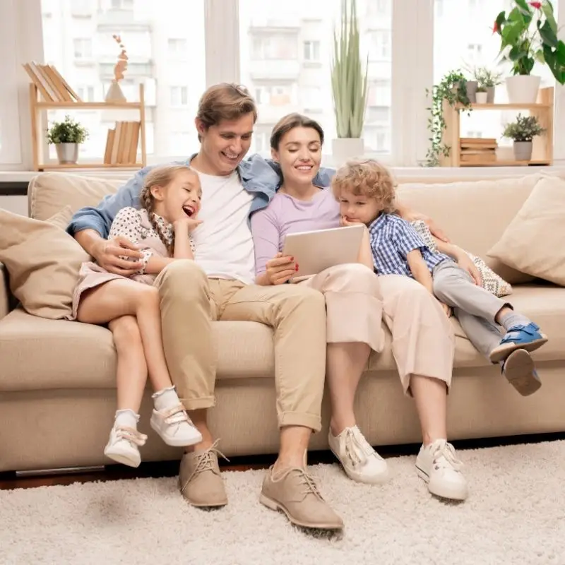 family relaxing on a couch in a clean living area