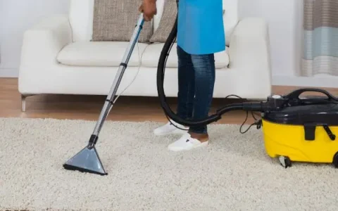 Cleaner vacuuming carpet in Manhattan apartment
