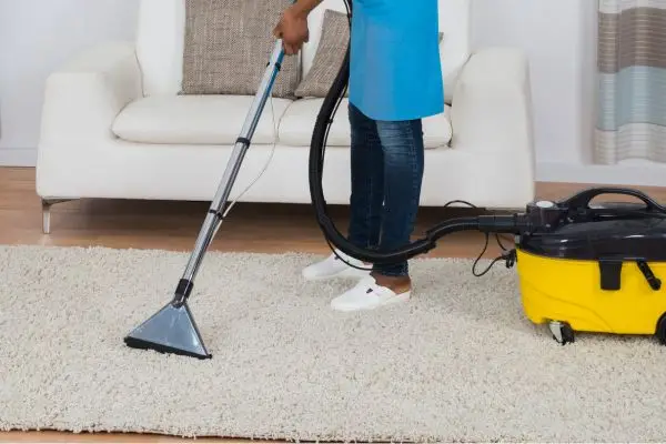 Cleaner vacuuming carpet in Manhattan apartment