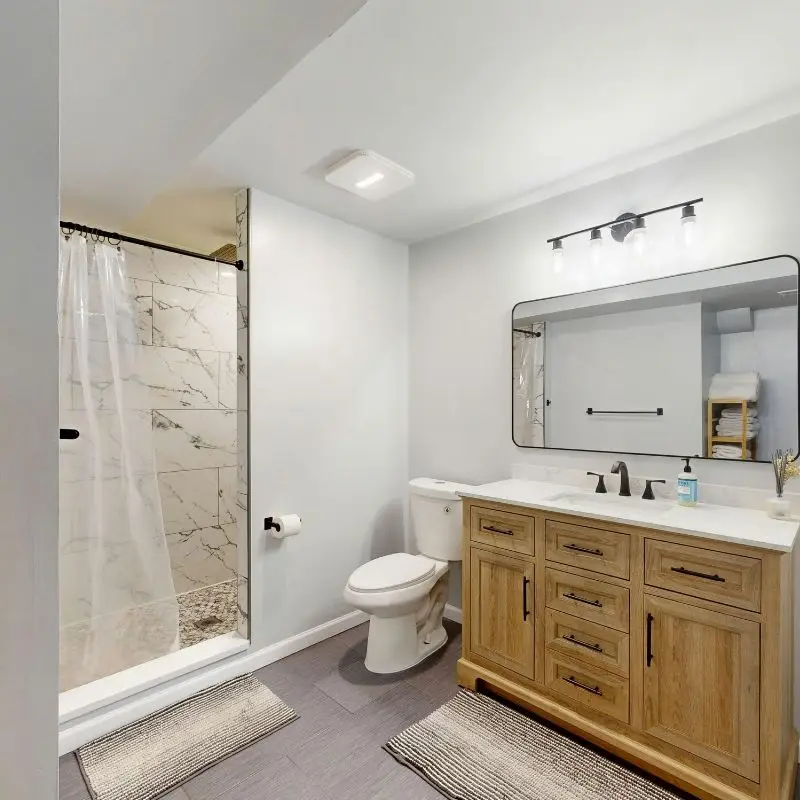 Clean bathroom with vanity, mirror and shower