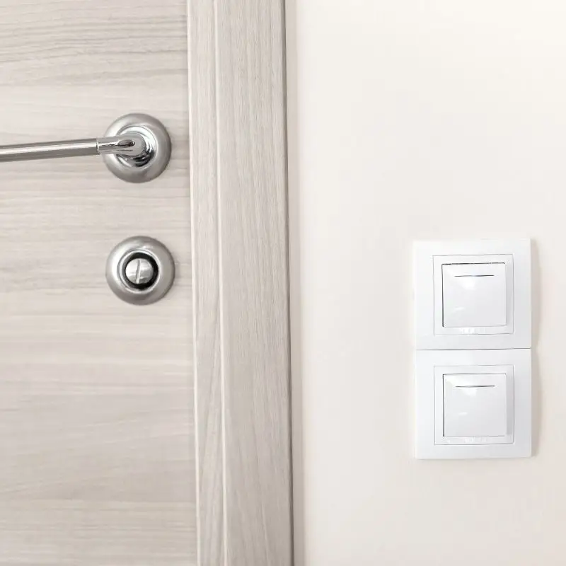 Close-up of door handle and light switch panel